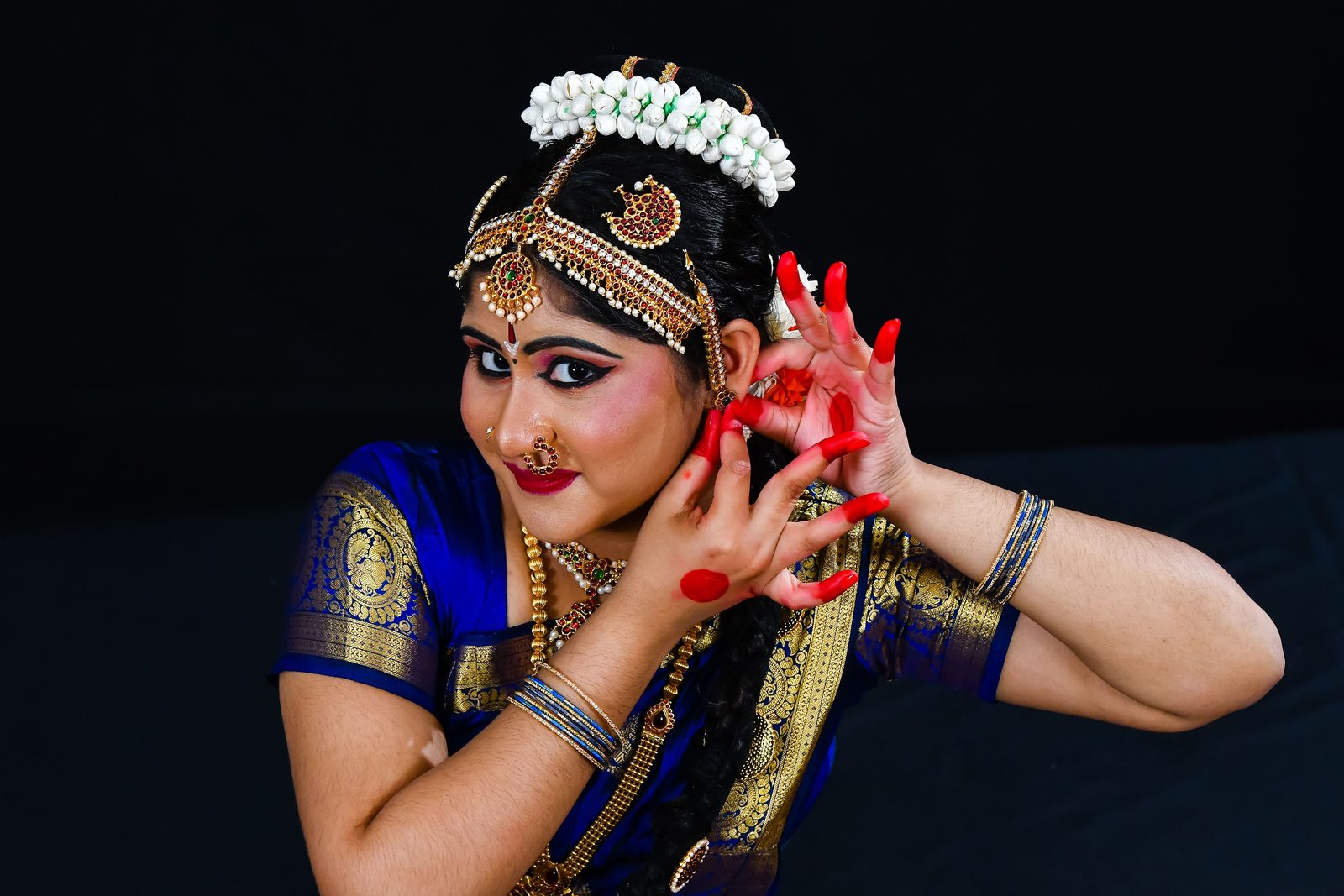 Close-up of an arangetram dancer framing her face with her hands