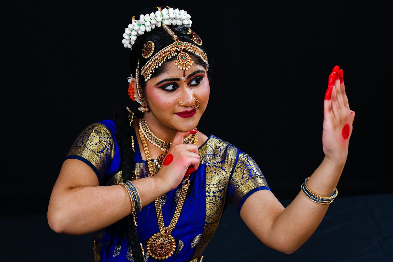 Arangetram dancer smiling with one hand raised
