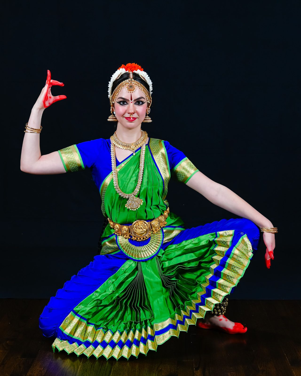 Arangetram dancer in green and blue, side pose