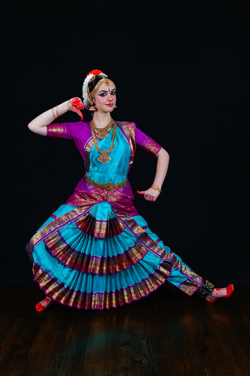 Arangetram dancer in purple and blue, side pose