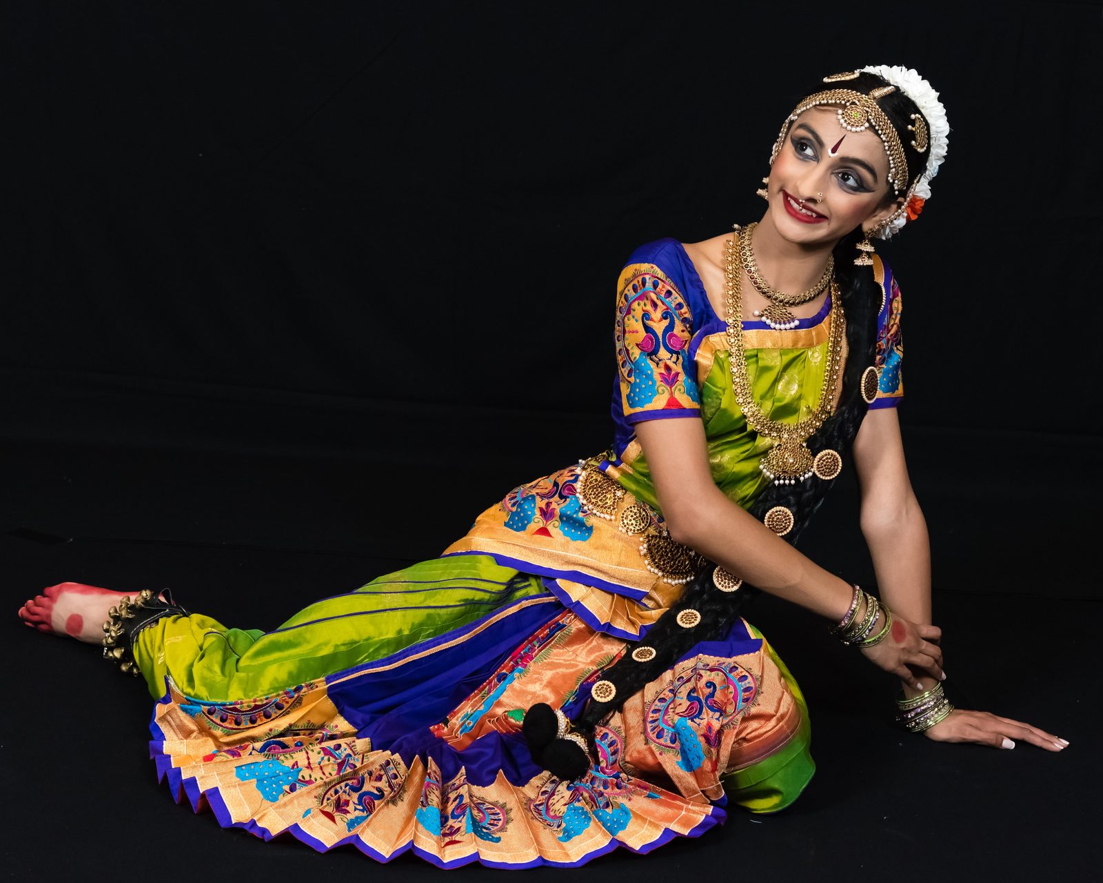 Arangetram dancer seated in a colorful costume