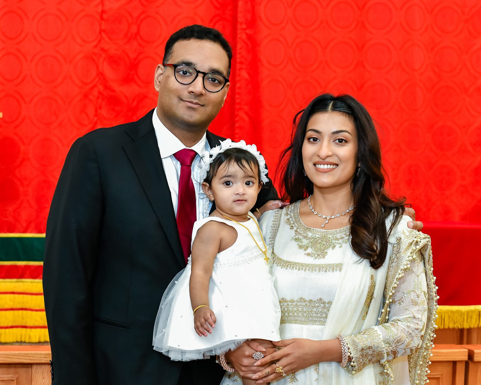 Parents holding their baby girl on her baptism day
