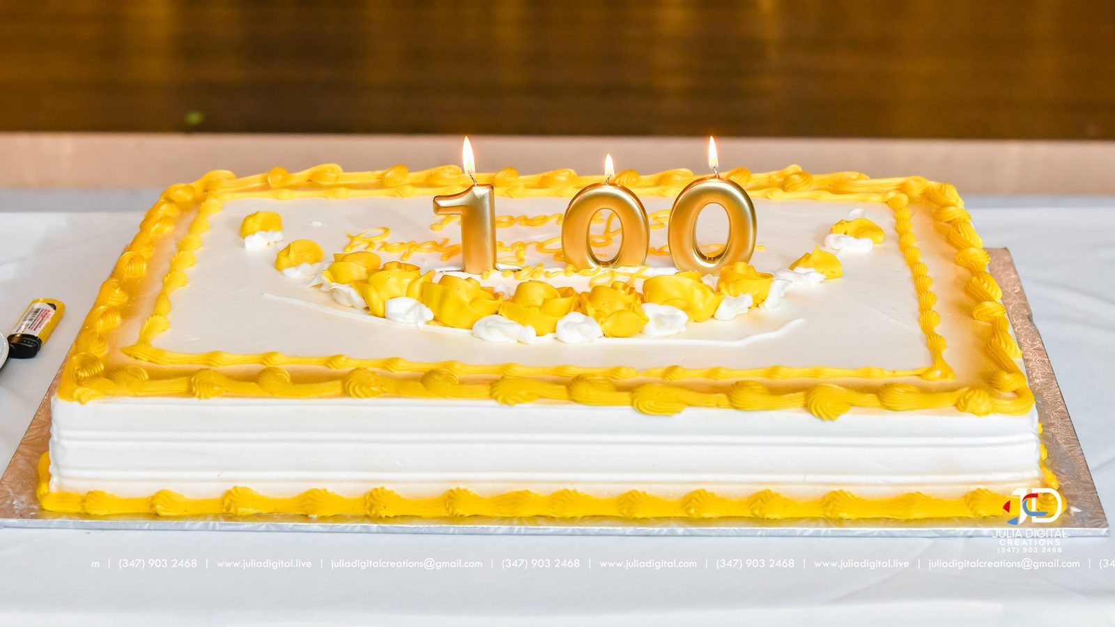 A 100th birthday cake with gold number candles