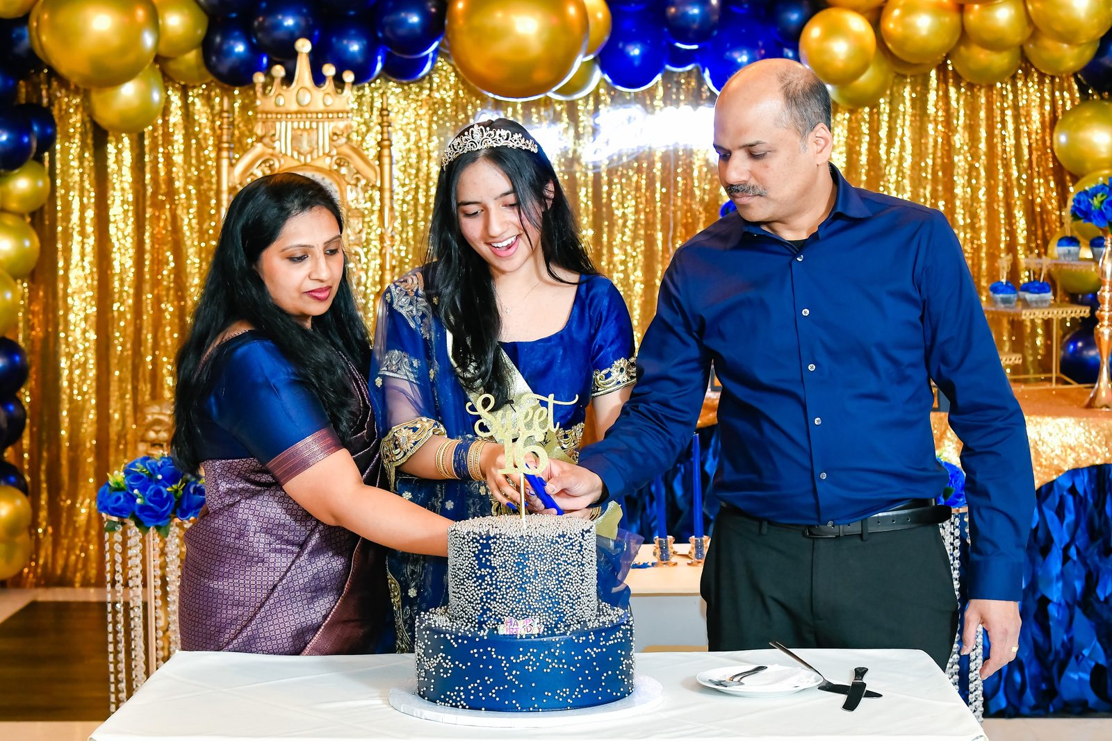 Teen cutting her birthday cake with her parents