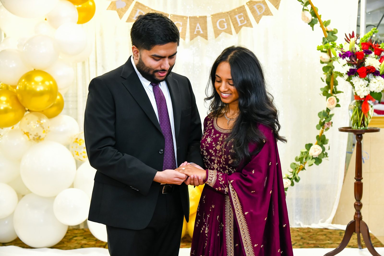 Engaged couple holding hands during the ring moment