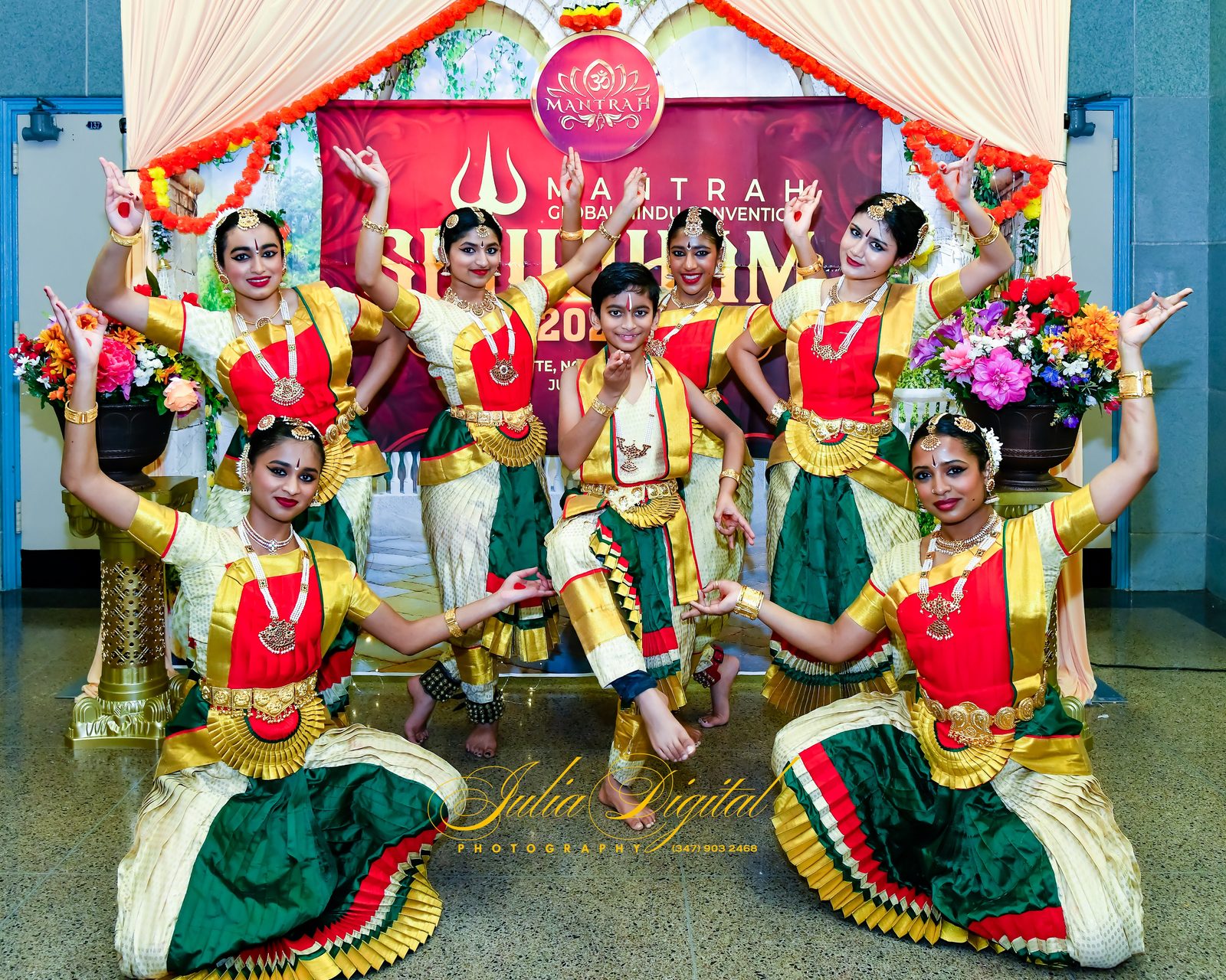 Dancers in costume posing in front of a convention backdrop