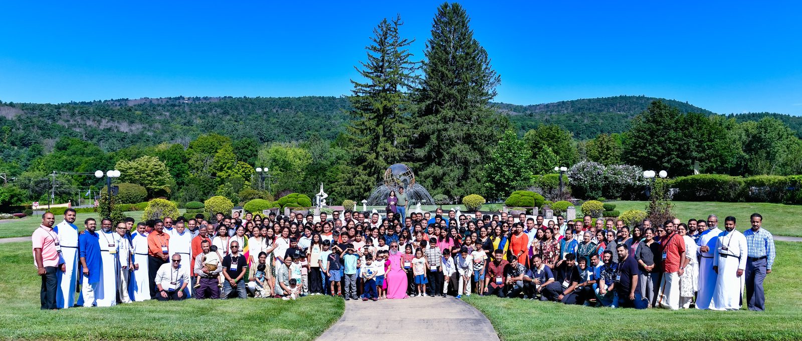 Large group photo on a lawn at a summer gathering