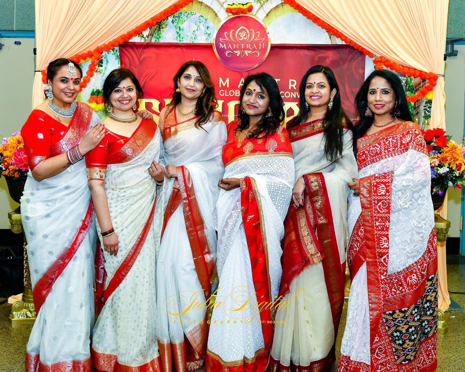 Group of women in red and white sarees at a convention