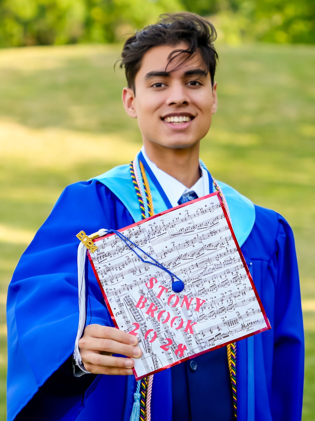 Graduate showing a decorated Stony Brook 2028 cap