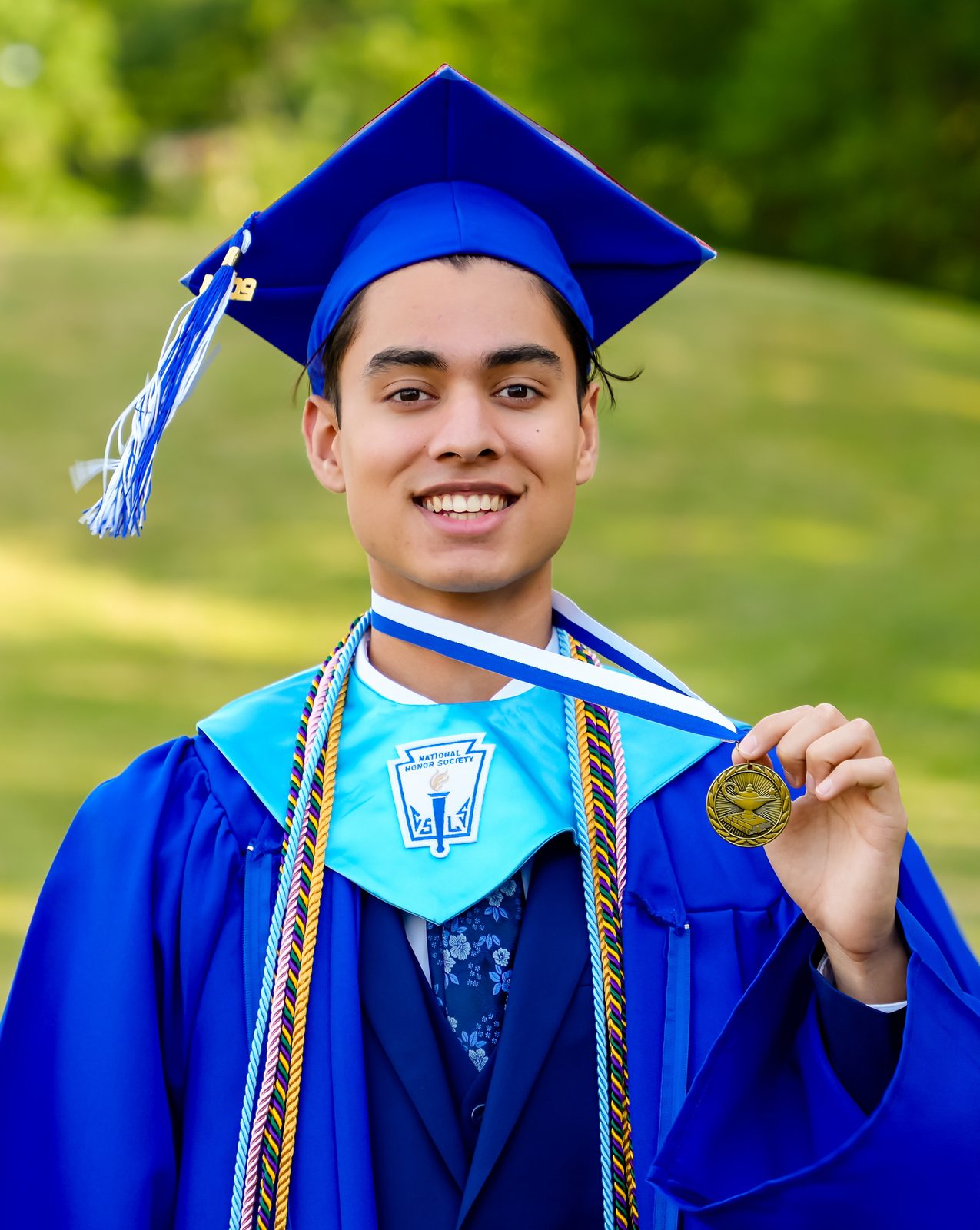 Graduate holding up his medal