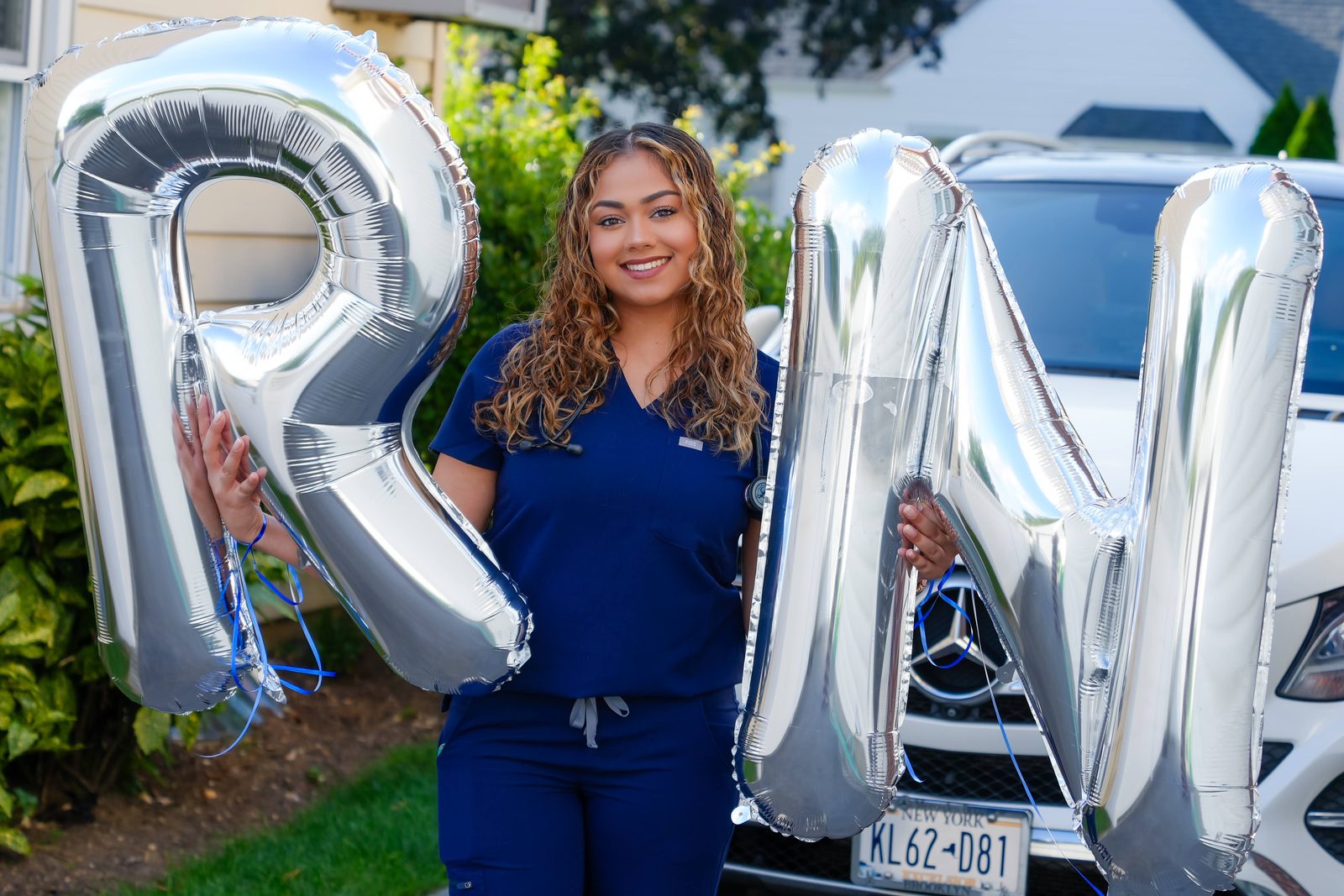 New nurse in scrubs with silver RN balloons