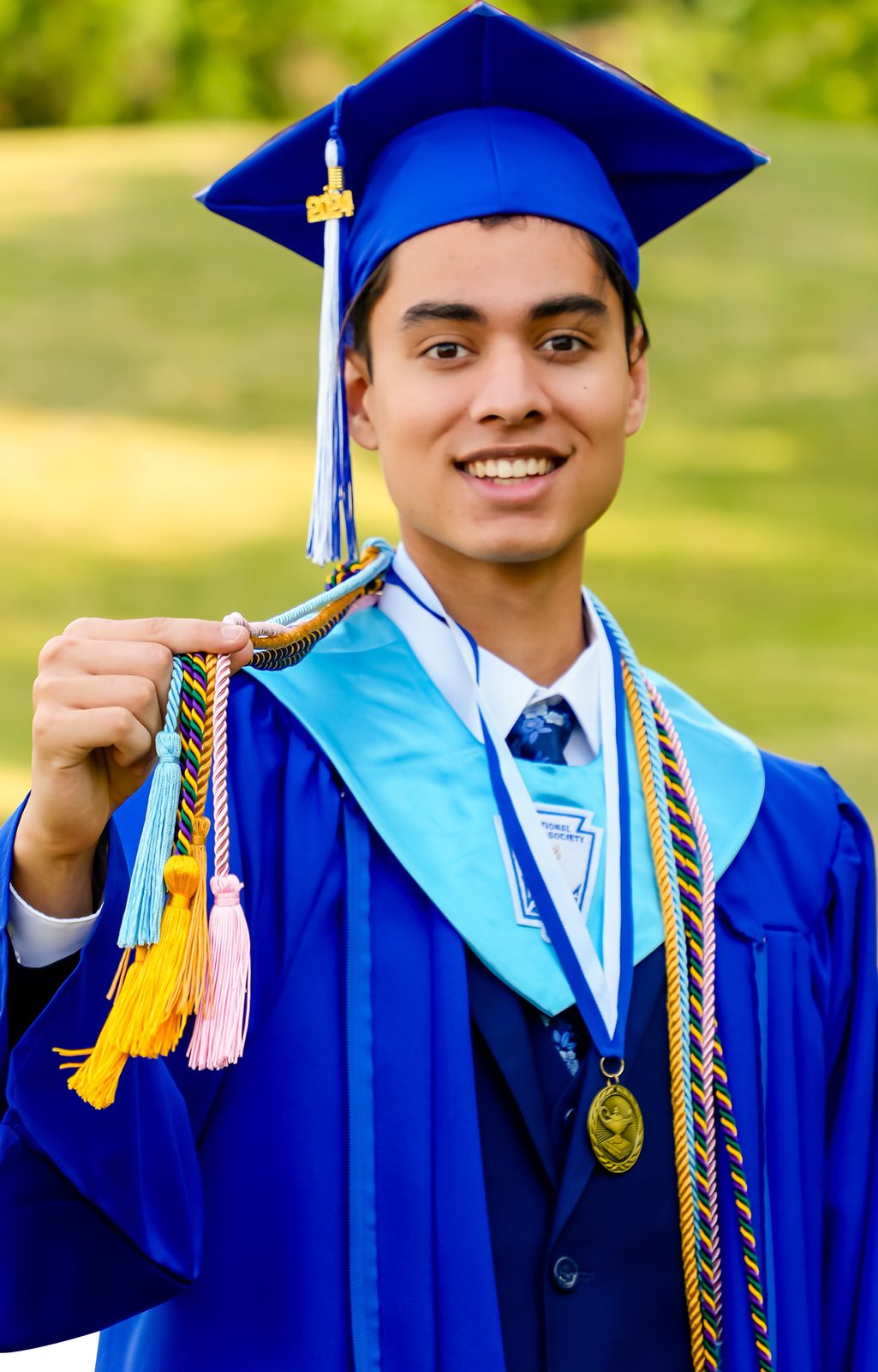 Graduate holding his cap tassel and cords