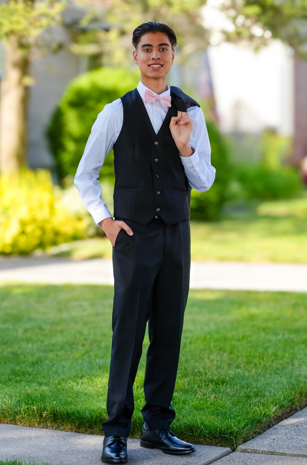 Standing on a lawn, jacket over shoulder